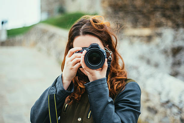 Young woman using DSLR camera A young woman using a DSLR camera slr camera stock pictures, royalty-free photos & images