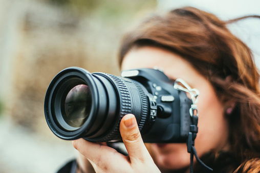 A young woman using a DSLR camera