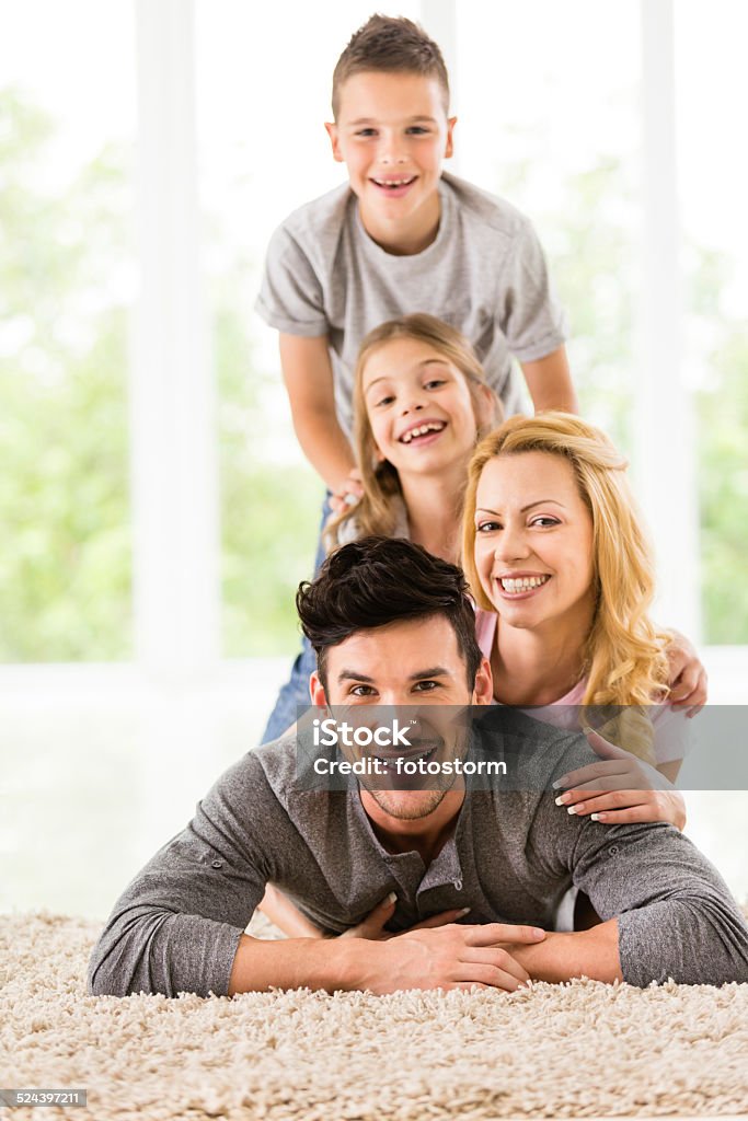 Happy family of four Happy family of four lying on the floor. Adult Stock Photo