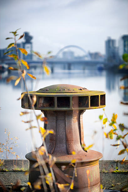 Derelict Graving Docks at Govan A rusting only iron capstan amongst the overgrowth at the derelict Victorian graving docks - a type of dry dock - in Govan, Glasgow, on the River Clyde. In the background is the modern Glasgow skyline. govan stock pictures, royalty-free photos & images