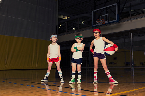 Retro-styled portrait of young children who are ready to school you in basketball.