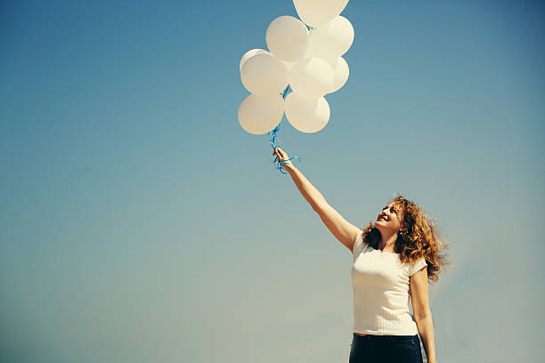 istock Beautiful woman holding balloons 524398470