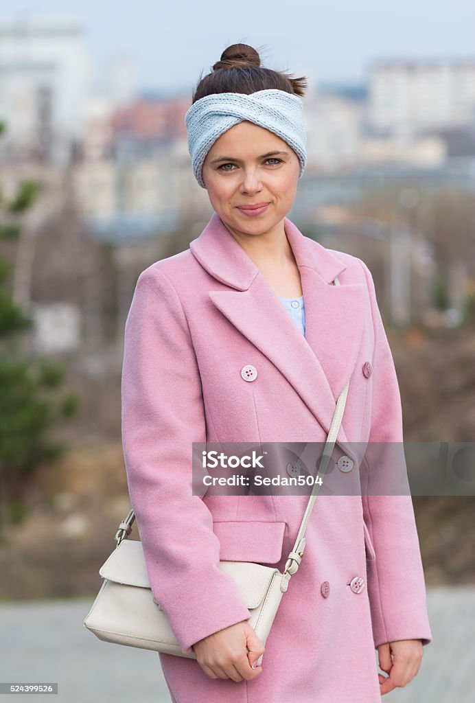 young girl in a pink coat and blue headband Headband Stock Photo