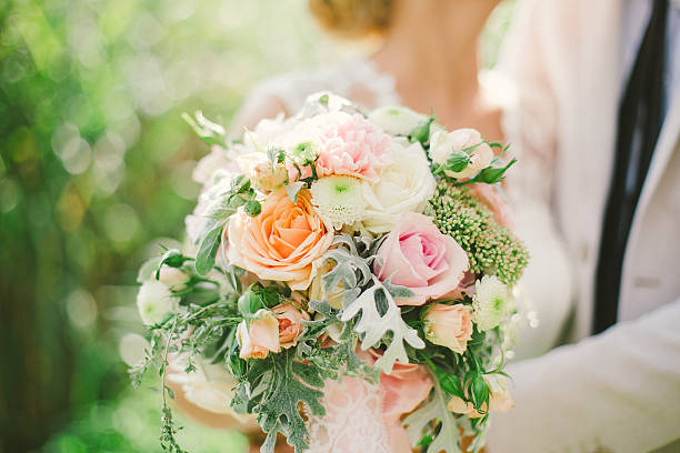 istock bride and groom holding wedding bouquet 524399995