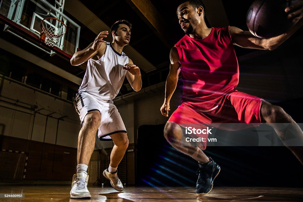 Young Men Playing Basketball Basketball player dribbling ball. Basketball - Ball Stock Photo