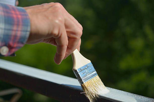 Man painting a guardrail