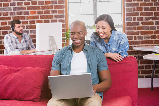 istock Casual colleagues using laptop on couch 524427579