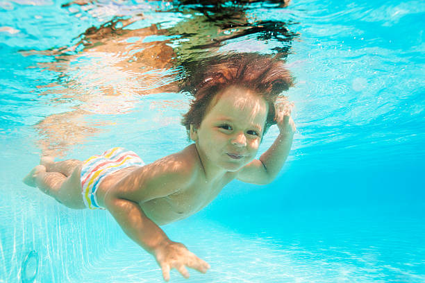 istock Cute smiling boy swimming under water of pool 524428839
