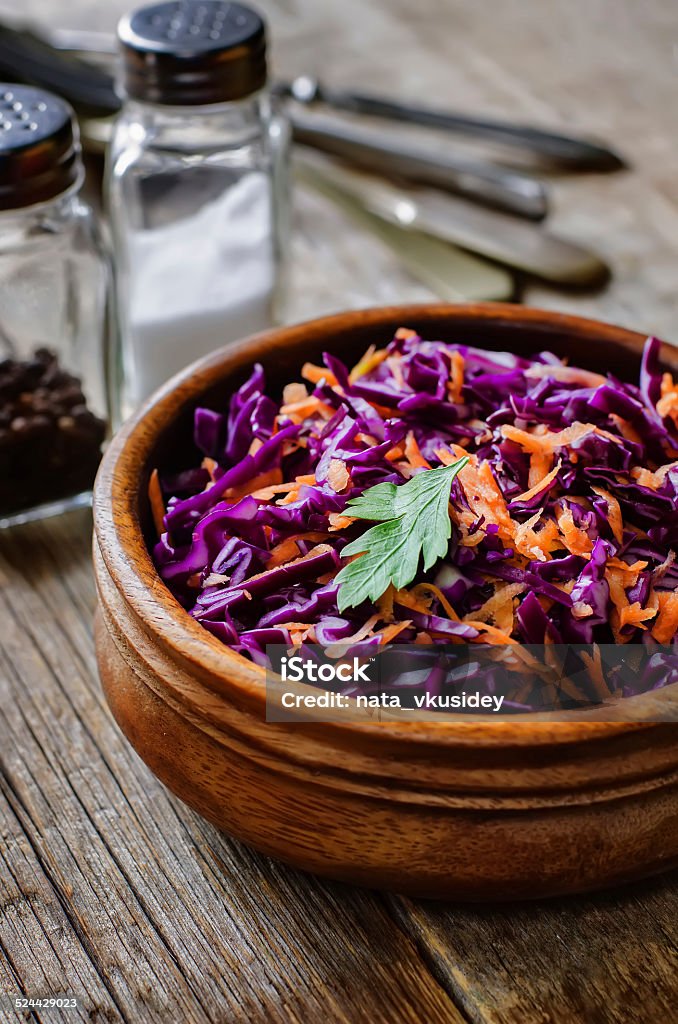 salad with carrots and red cabbage salad with carrots and red cabbage on a dark wood background. tinting. selective focus on parsley Appetizer Stock Photo