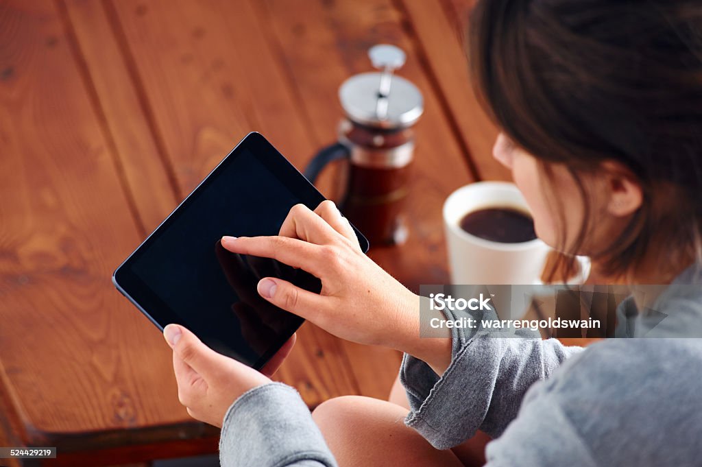 modern woman Young woman uses tablet while relaxing at home with coffee on the sofa couch Adult Stock Photo