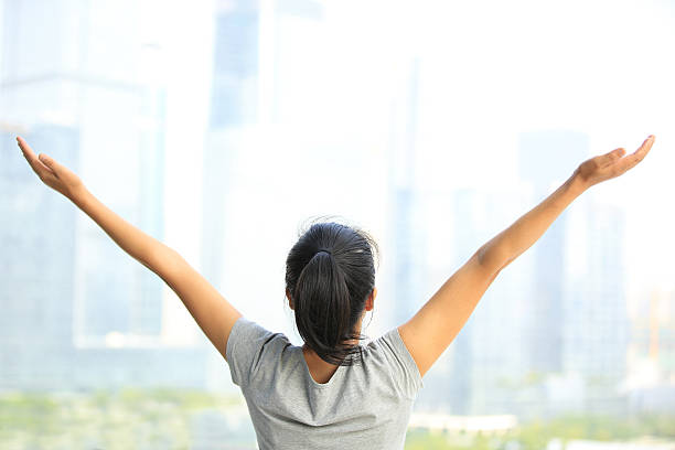 istock cheering woman open arms at city 524430465
