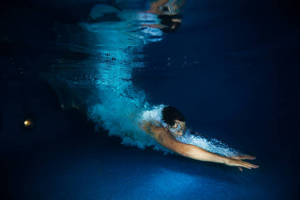 homem com splash nadando na água azul escuro - bubble swimming pool water underwater - fotografias e filmes do acervo