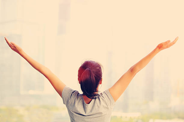 istock cheering woman open arms at city 524448243