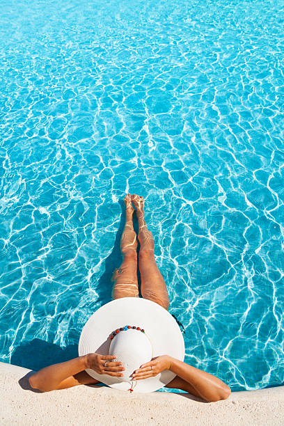 istock Girl holding white hat with hands in swimming pool 524448889