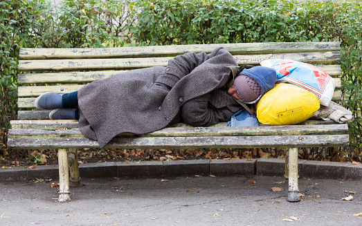 Sofia, Bulgaria - November 4, 2014: Homeless man is sleeping on a bench in the center of Sofia. Years after joining the EU Bulgaria is still the poorest country in the union.