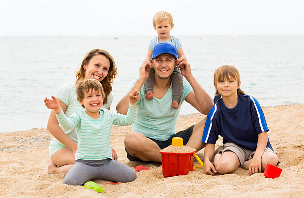 istock Positive parents with kids sitting at sandy beach 524453127