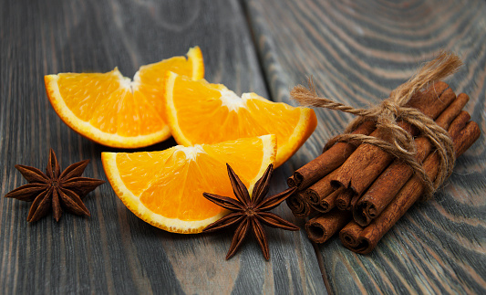 Orange with cinnamon sticks on a wooden background