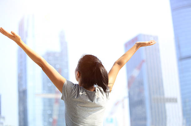 istock cheering woman open arms at city 524453607