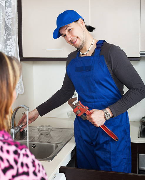 istock Joyful plumber repairing running water 524477971