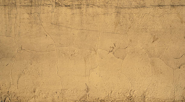 istock Texture of old wall covered with yellow stucco 524478587