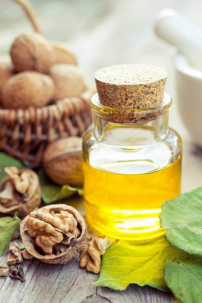 istock Walnuts, bottle of essential oil and basket with nuts 524478629
