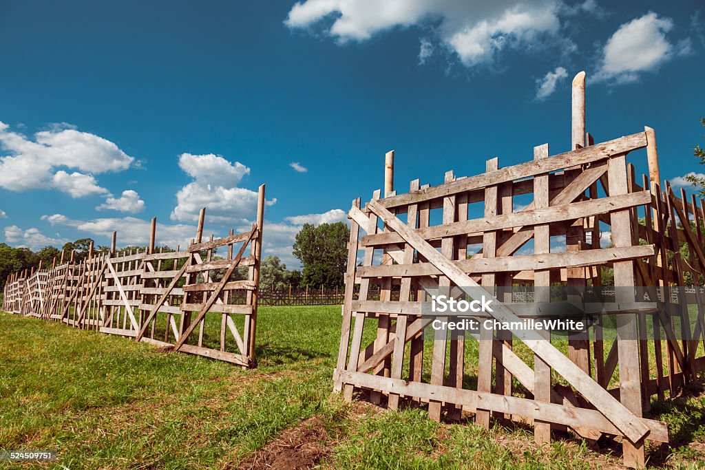 wooden rustic fence, sky and village landscape wooden rustic fence, blue sky and village landscape Agricultural Field Stock Photo