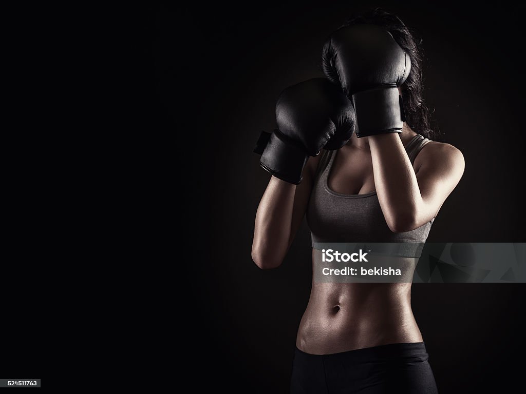 Boxing woman on dark background Boxing girl on black background holding gloves up Women Stock Photo