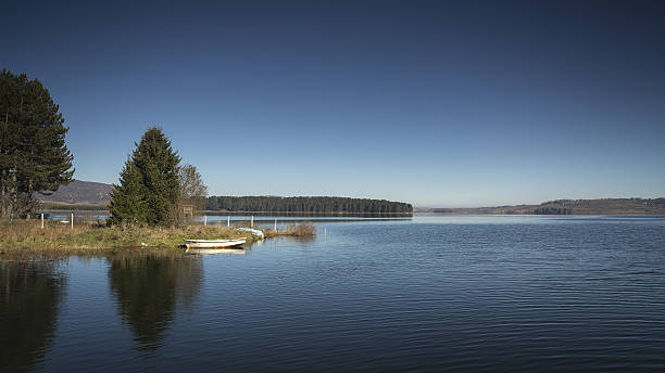 istock Blue lake, white boat, green hill 524511915