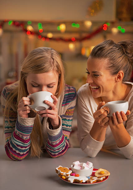 istock Smiling two girlfriends having snacks in christmas decorated kitchen 524512915