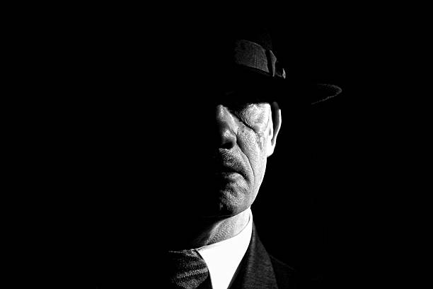 black and white ,film noir style portrait of gangster in fedora hat