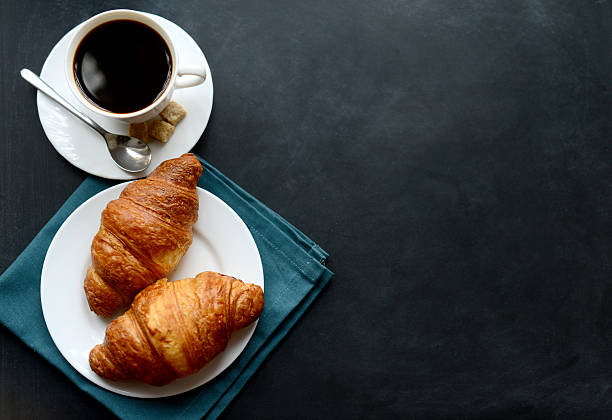 tasse de café et des croissants sur fond noir - cafe breakfast coffee croissant photos et images de collection