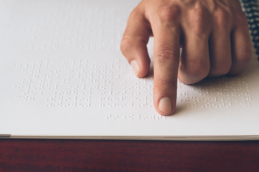 Visually impaired old person learning to reading by touch.