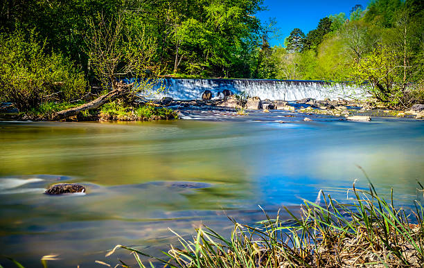 Slow moving waters of Eno River The Eno River State Park is one of the best natural parks located in Durham, North Carolina. It is in the northern part of the city, just a few miles away from Duke University. It consists of a thick forest of varied trees basically oak, maple, pine and other evergreens. It also has  various walking trails where you can meet lots of friends enjoying the walk, while seeing beautiful wildlife along the way. This image was taken during spring season. eno river stock pictures, royalty-free photos & images