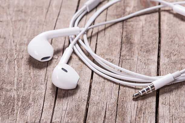 istock White earbuds on wooden table 524536394
