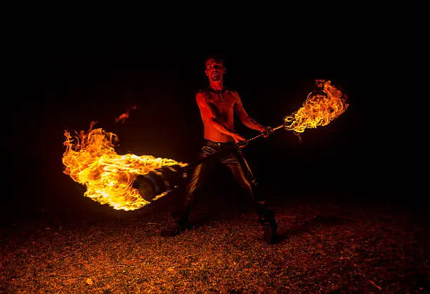 Man Fire Staff Spinning Outside at Night