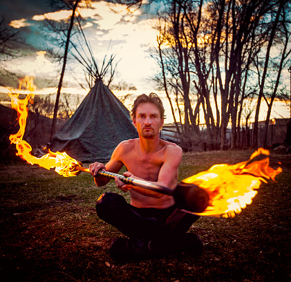 Man Fire Staff Spinning Outside at Sunset
