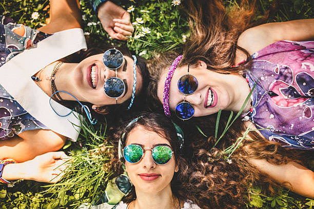 Beautiful girls of hippie laying on the grass and daisy flowers