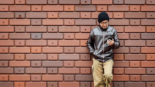 istock Asian Man in a Brown Jacket with His Smartphone 524537850