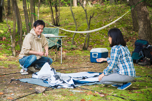 Young couple pitching a tent together. Okayama, Japan. April 2016