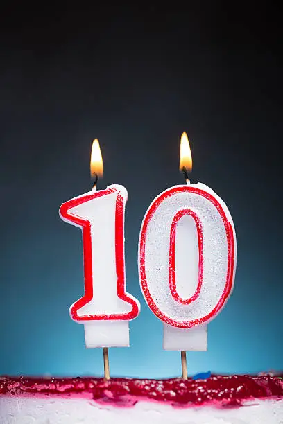 Flaming Birthday candles against dark, blue, spot  background. Canon 5D MK III