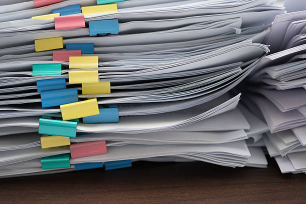 istock two piles of documents with colorful clips on desk 524539776