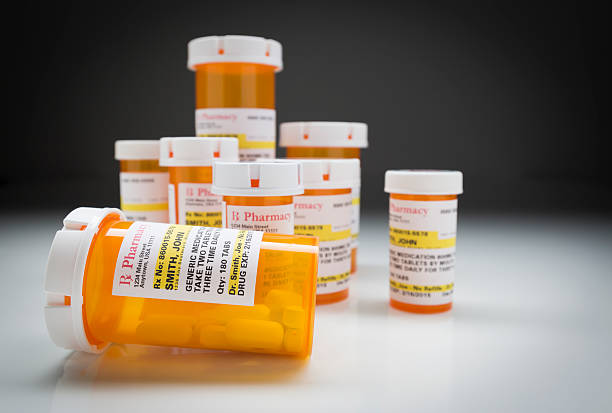 istock Medicine Bottles on Reflective Surface and Grey Background 524540910
