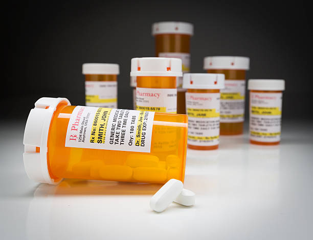 istock Medicine Bottles and Pills on Reflective Surface With Grey Backg 524541236
