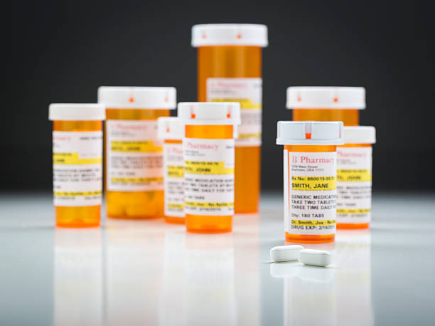 istock Medicine Bottles and Pills on Reflective Surface With Grey Background 524541288