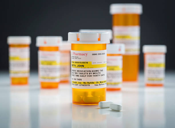 istock Medicine Bottles and Pills on Reflective Surface With Grey Background 524541298