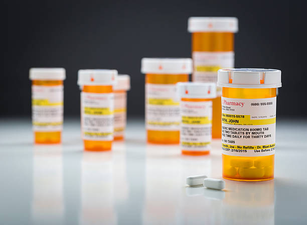 istock Medicine Bottles and Pills on Reflective Surface With Grey Background 524541324