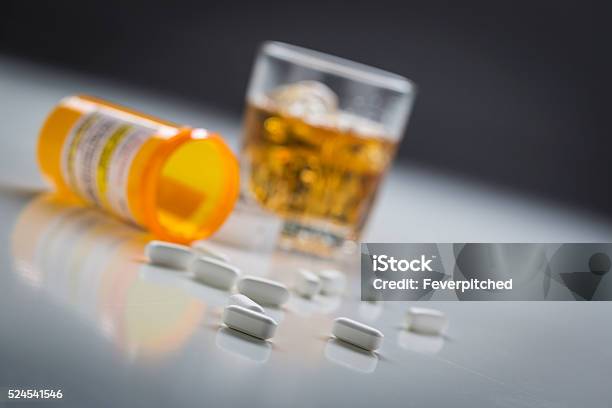 Prescription Drugs Spilled From Fallen Bottle Near Glass Of Alcohol Stock Photo - Download Image Now