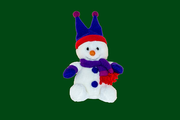 a shot of a toy snowman covered in snow and with a carrot for a nose!