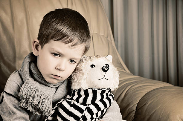istock tinted image sad little boy hugging toy dog 524541883