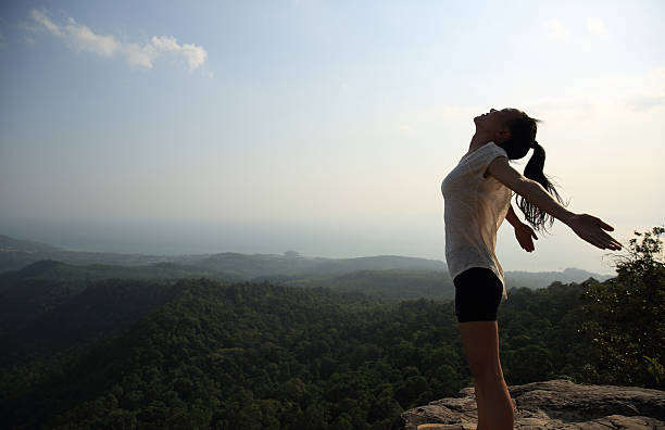 istock young freedom woman open arms on mountain peak 524541912